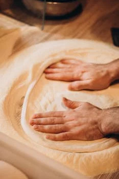 pizza chef kneading dough in kitchen